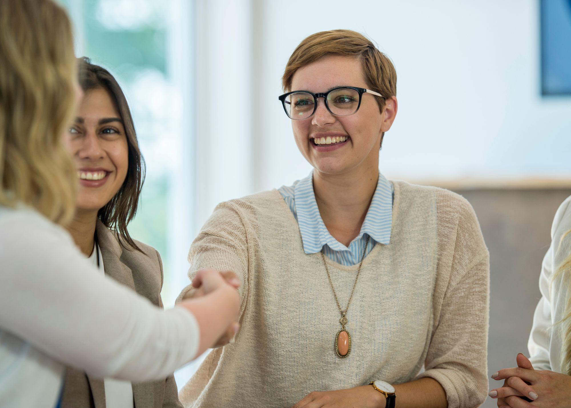 Young woman in glasses meeting conference member